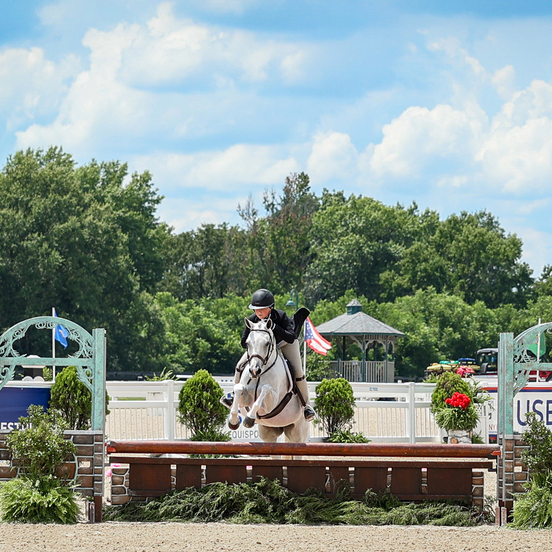 Mounted rider and pony jumping a fence at the USEF Pony Finals